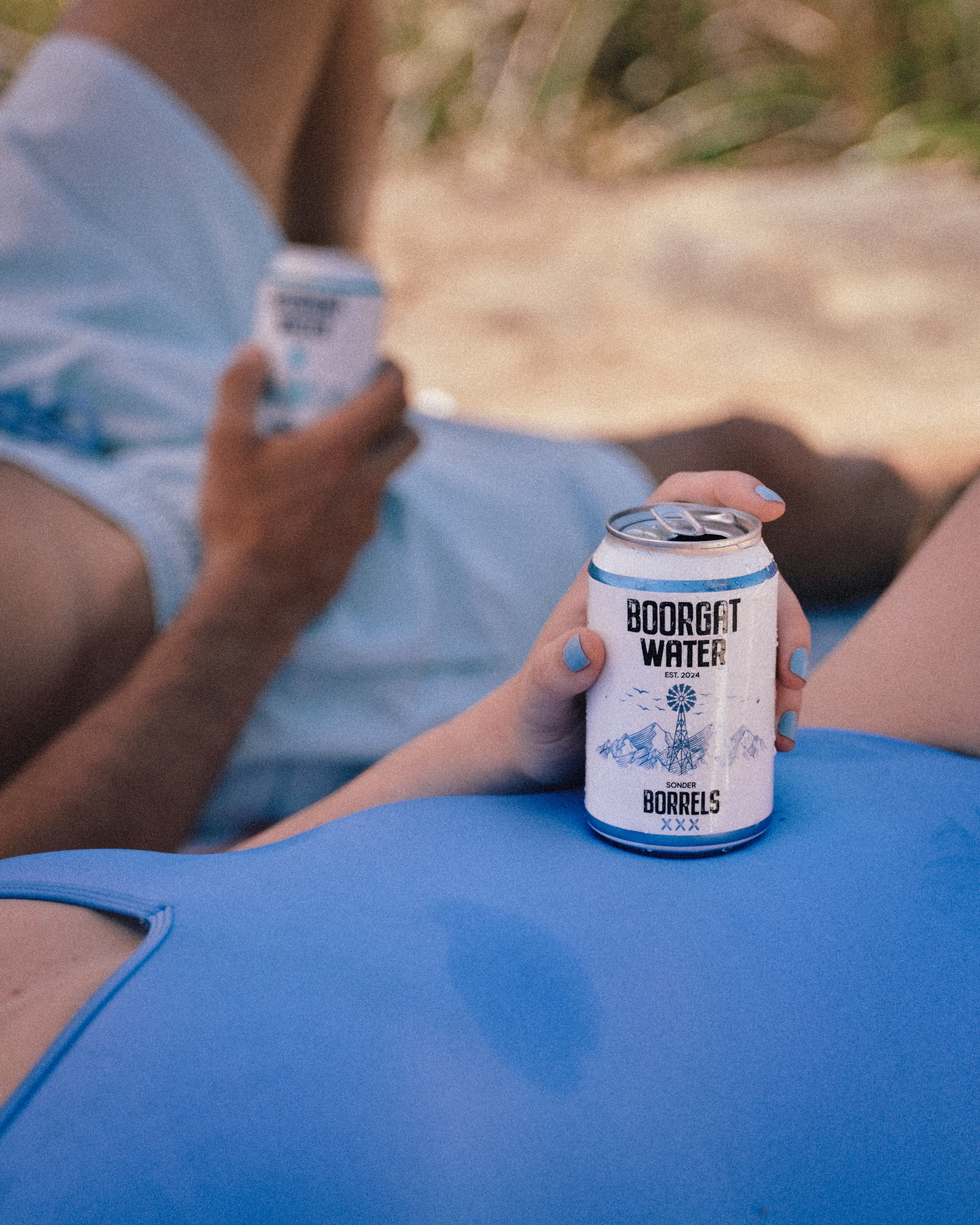 Person holding a can of Boorgat Water outdoors